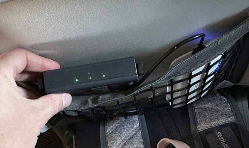 Travel router in seat back pocket with battery pack. You could also just leave it in your suitcase/backpack for the flight.