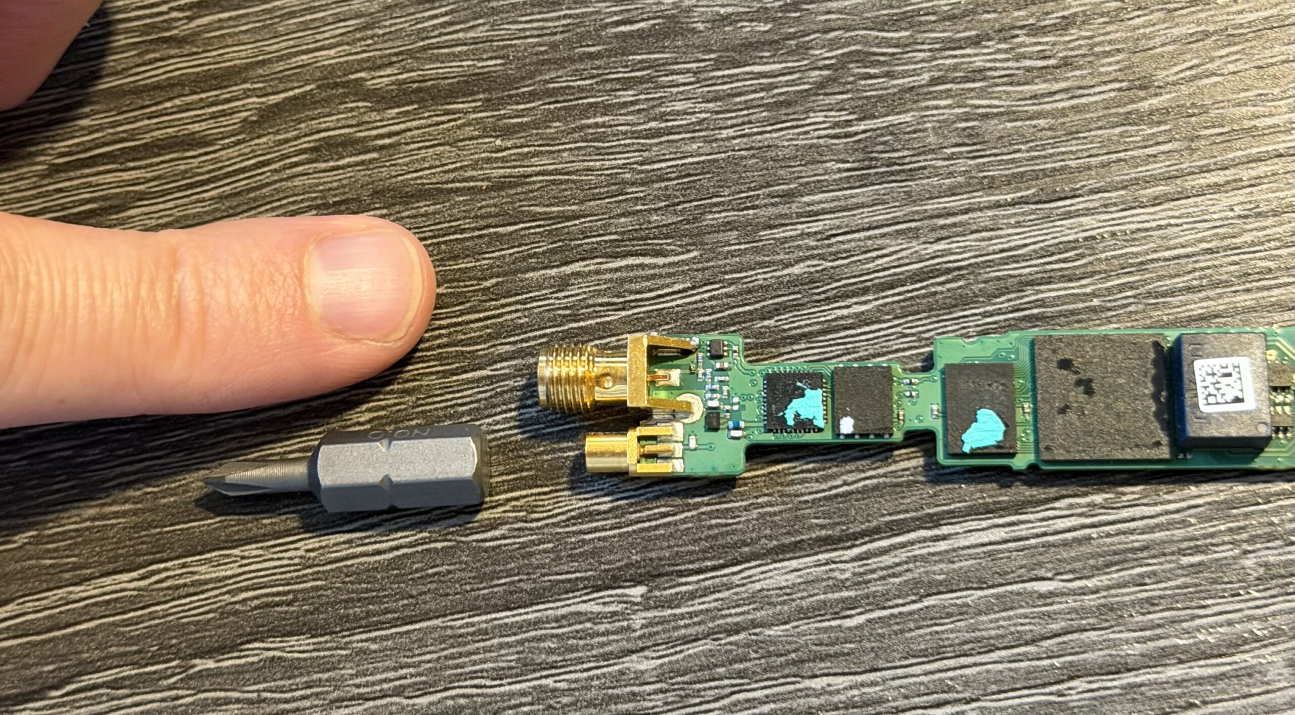 OSA-5401 PCB with resoldered GNSS SMA connector, screwdriver bit for scale